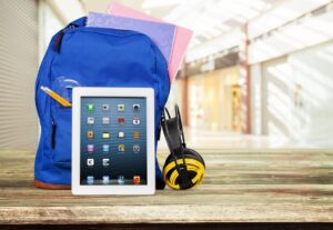 Digital tablet and school supplies in backpack